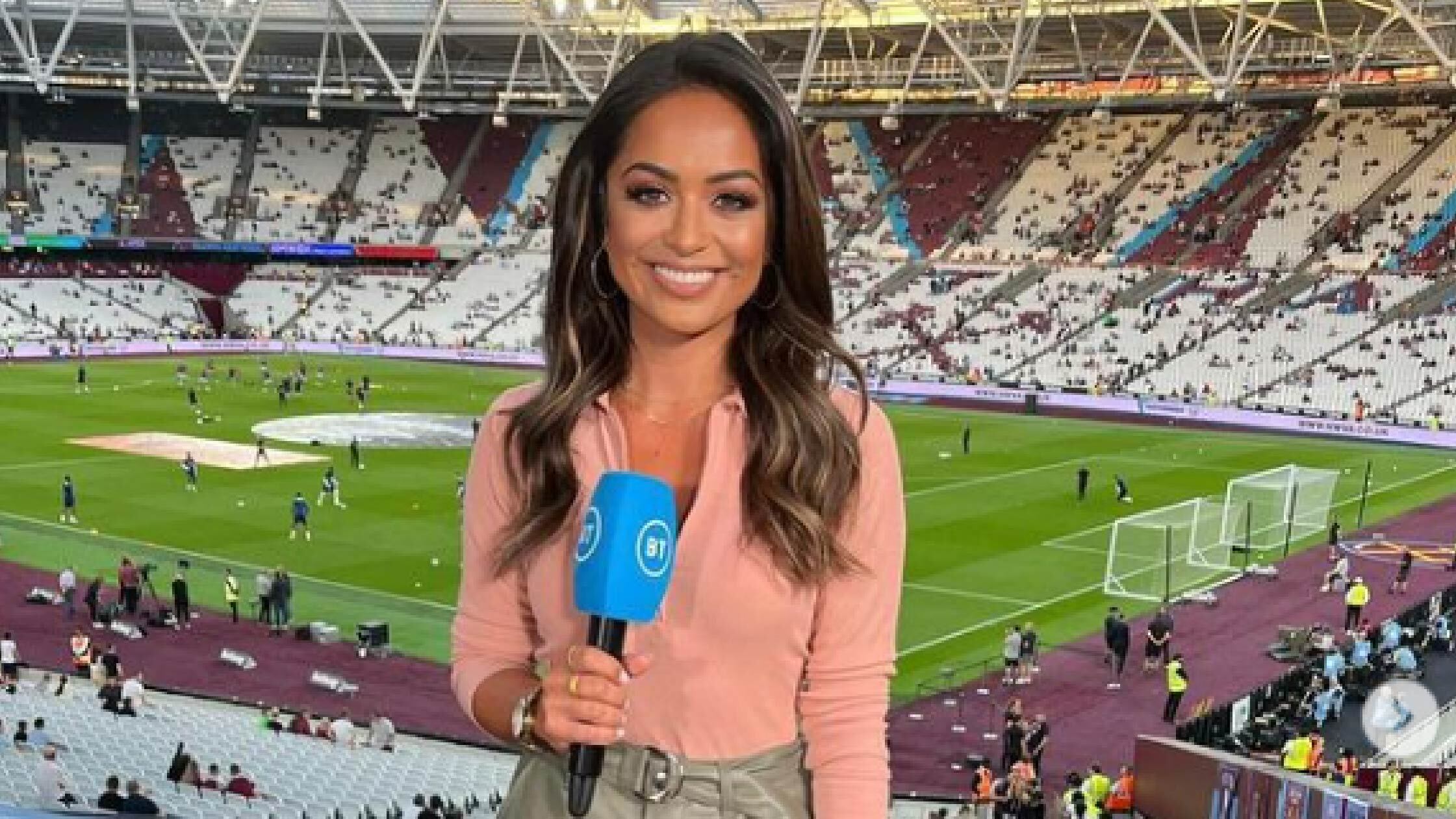 Breach standing in a stadium with a mic in her hands. 