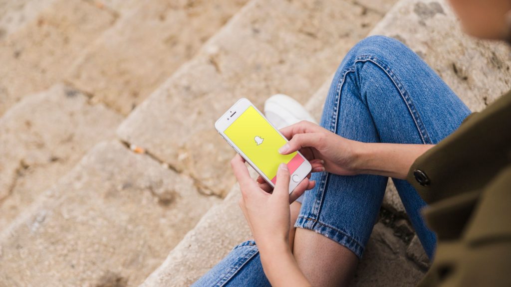 A girl using Snapchat on phone.