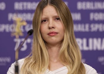 Mia Goth wearing a white dress in an event.