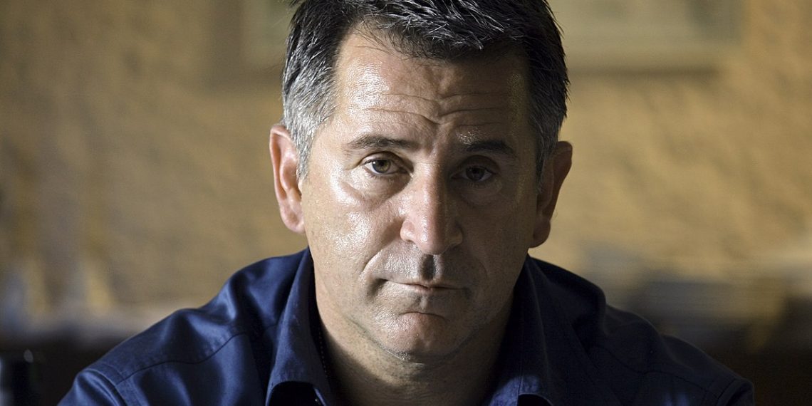 Anthony Lapaglia wearing a blue shirt and looking straight in camera.