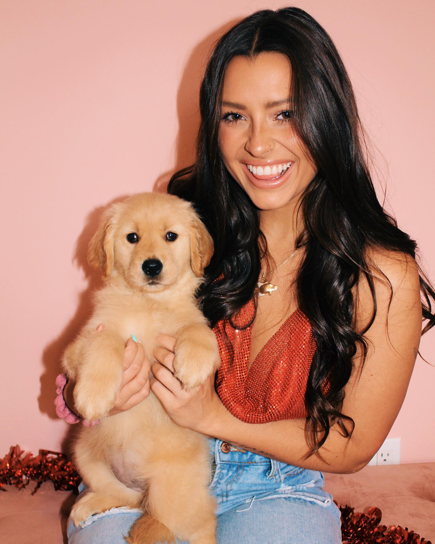 Wren wearing red colored dress and holding a puppy.